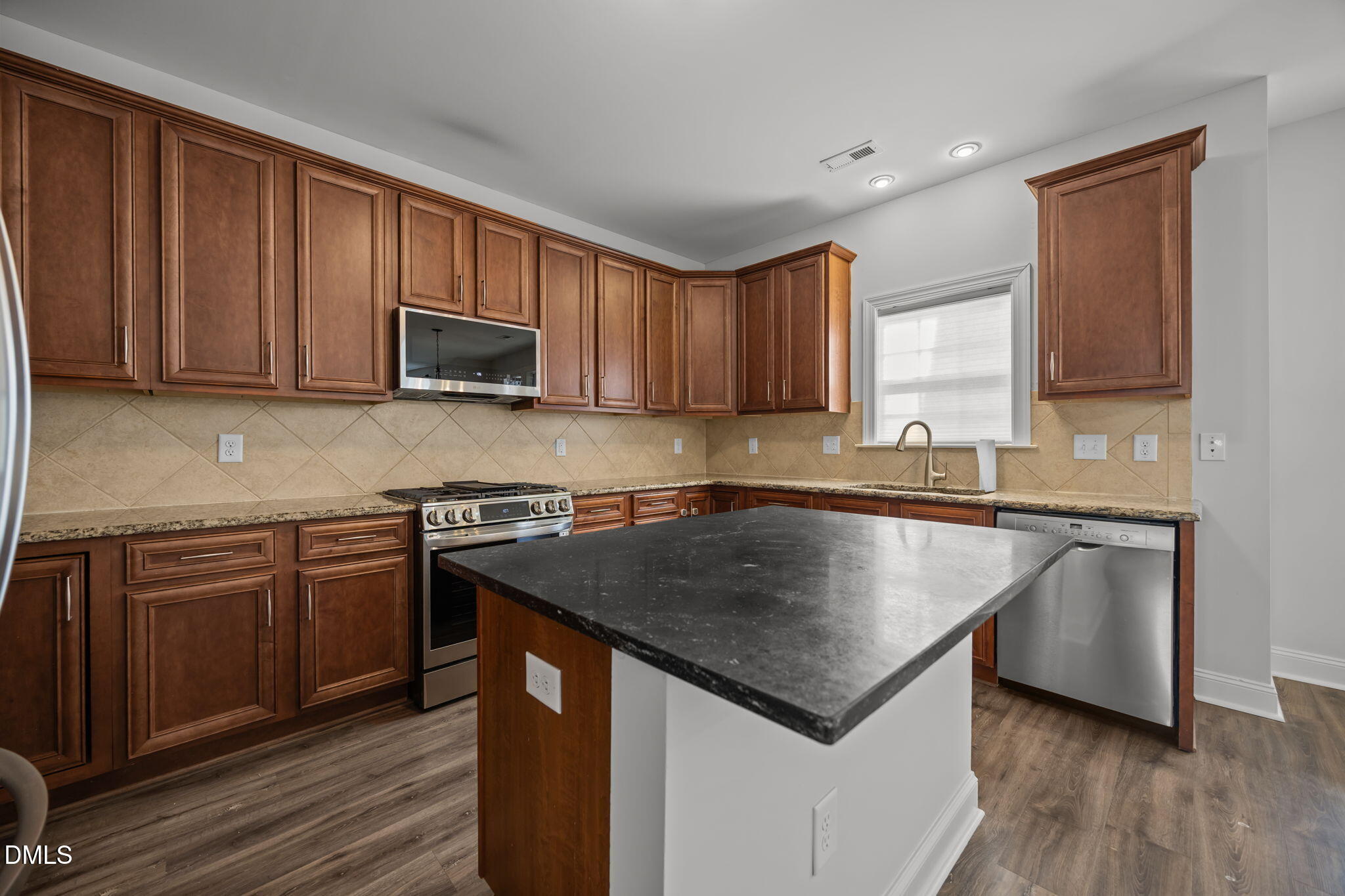 824 Lone Pine Loop Fuquay-Varina, NC 27526 - Photo 12 of 62 a kitchen with kitchen island granite countertop a stove sink and cabinets