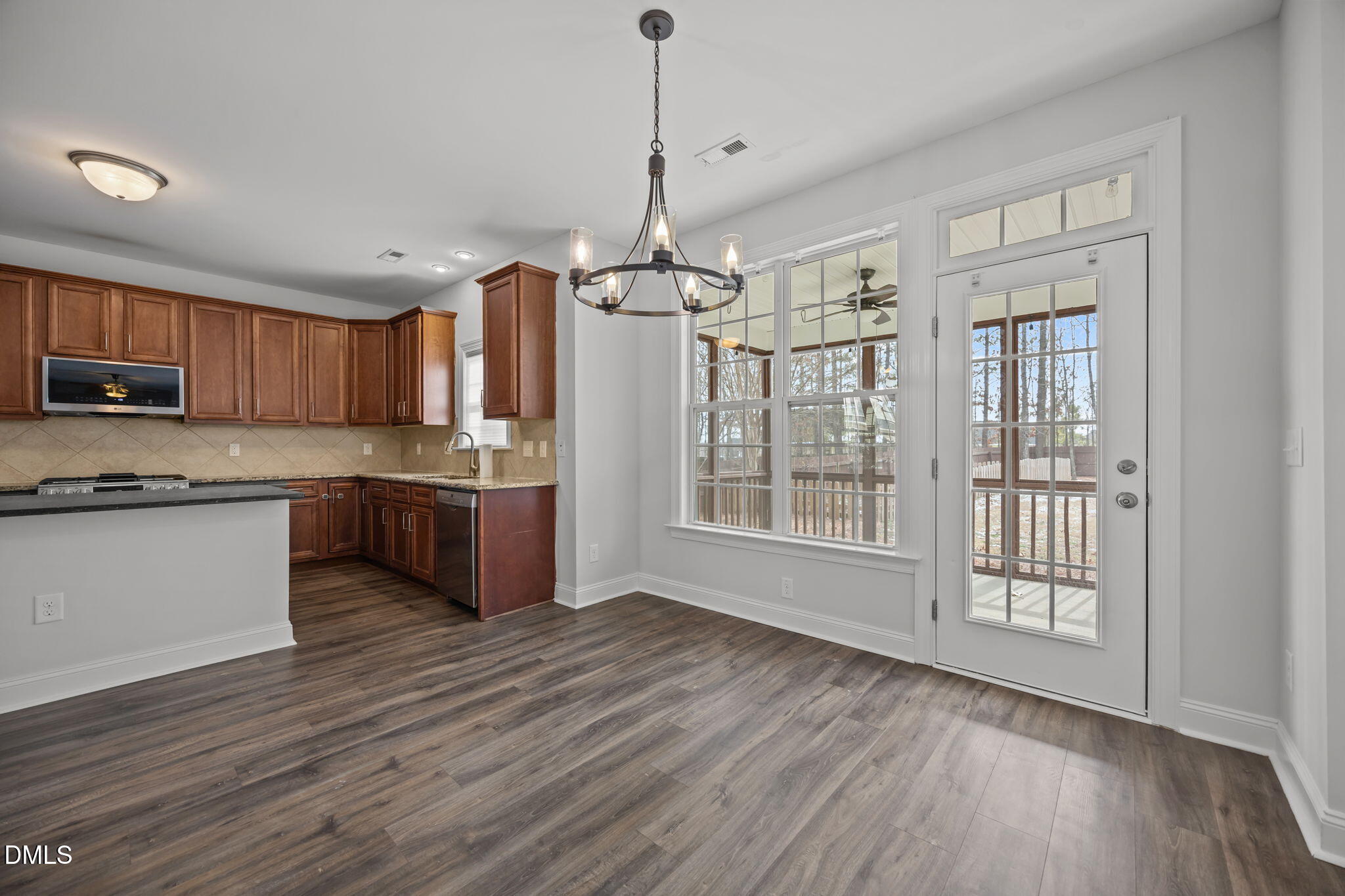 824 Lone Pine Loop Fuquay-Varina, NC 27526 - Photo 15 of 62 a open kitchen with kitchen island granite countertop wooden floors and stainless steel appliances