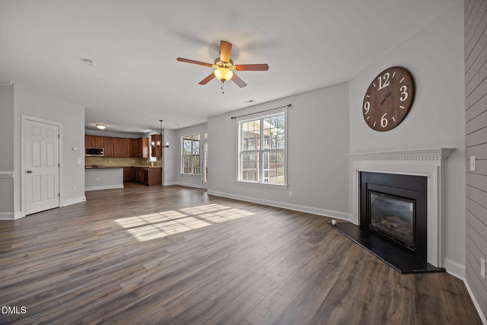 824 Lone Pine Loop Fuquay-Varina, NC 27526 - Photo 18 of 62 a view of a livingroom with a fireplace a ceiling fan and wooden floor