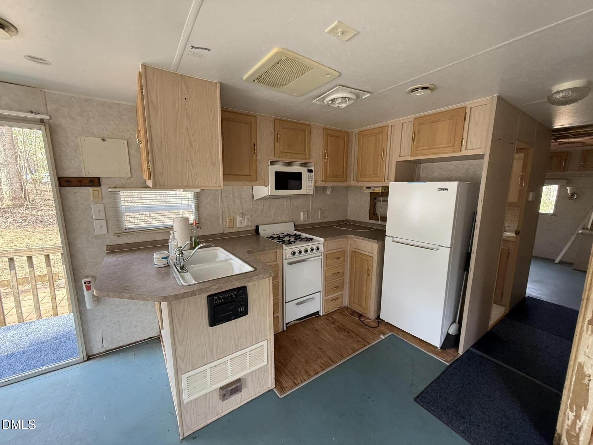 105 Kansas Drive Spring Hope, NC 27882 - Photo 14 of 54 a kitchen with refrigerator cabinets and wooden floor