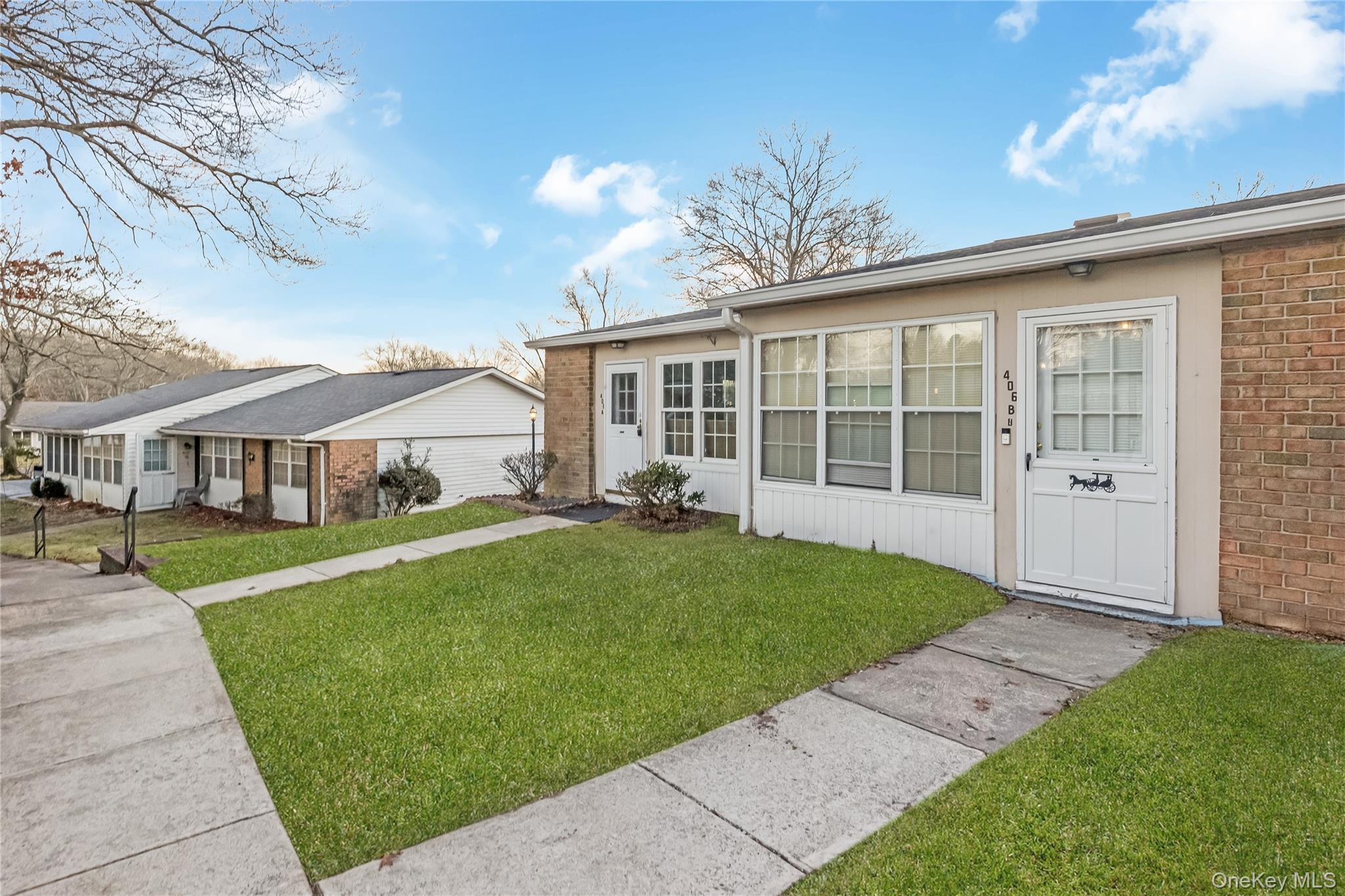 406 Woodbridge Drive, Unit B Ridge, NY 11961 - Photo 3 of 15 a view of a house with a garden