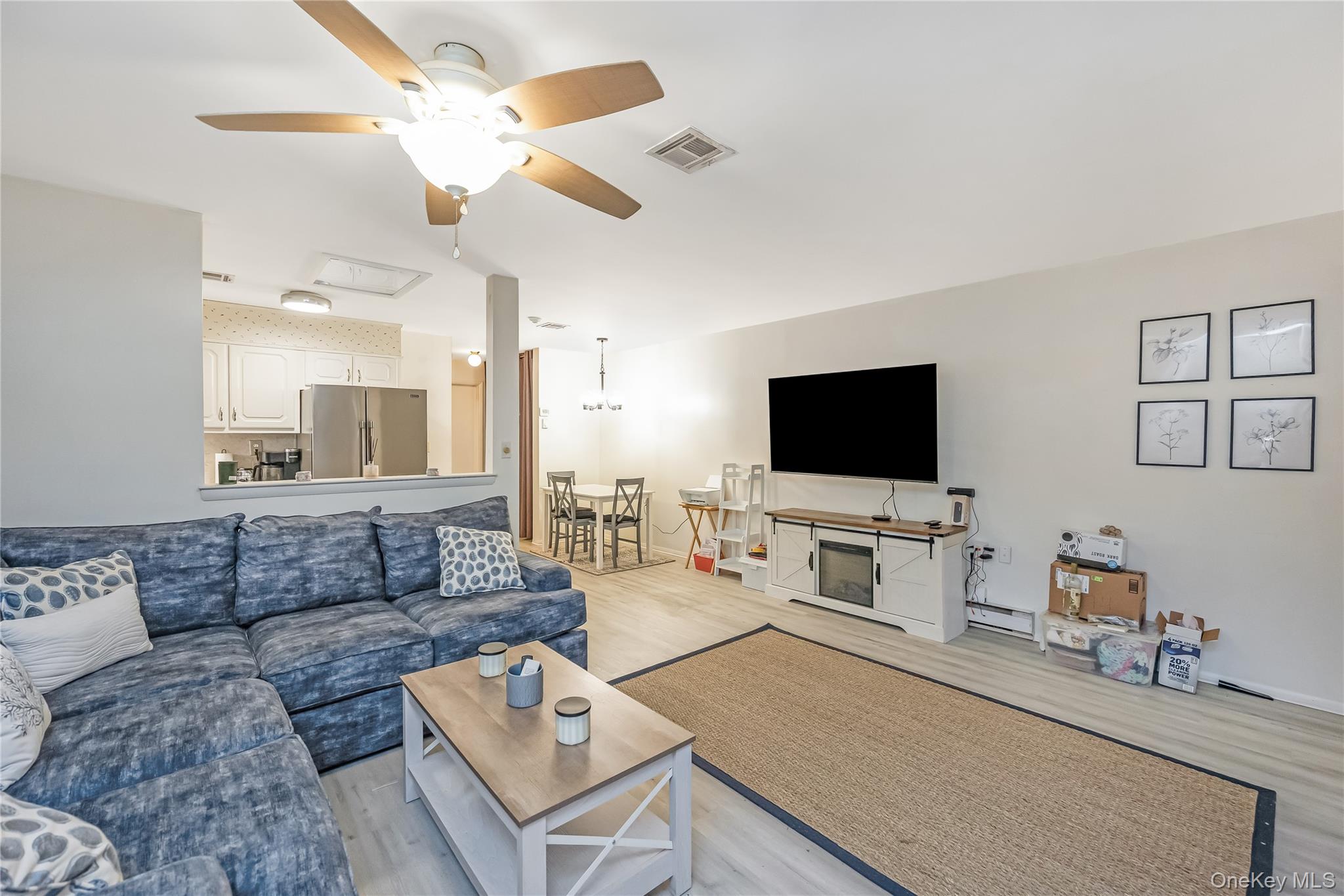 406 Woodbridge Drive, Unit B Ridge, NY 11961 - Photo 8 of 15 a living room with furniture and a flat screen tv