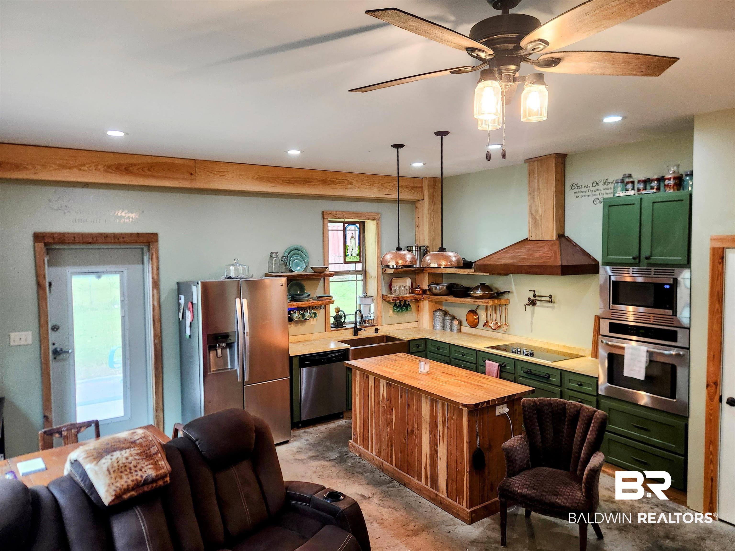 15461 Highway 98 Foley, AL 36535 - Photo 4 of 28 Kitchen with range hood, green cabinetry, butcher block counters, and appliances with stainless steel finishes