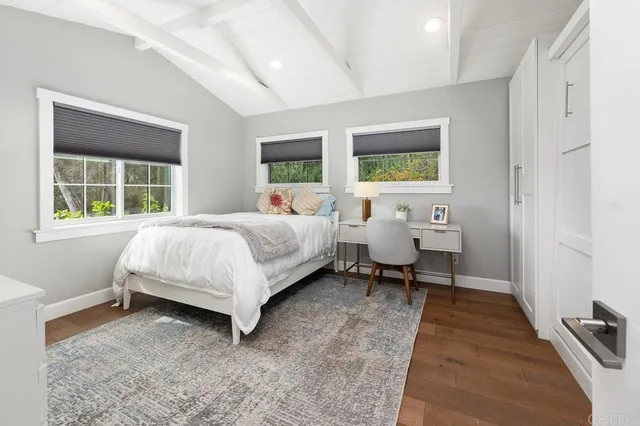 a bedroom with a bed and a flat tv screen on wall