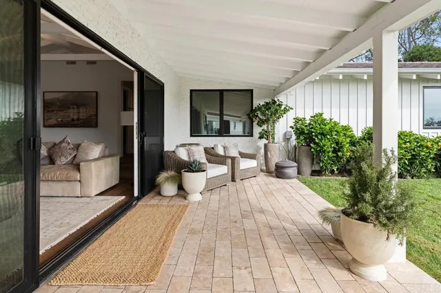 a patio with a table and chairs under an umbrella