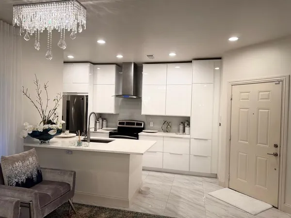 a kitchen with a sink stainless steel appliances and chandelier