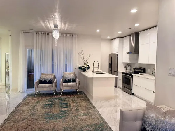 a large white kitchen with a large window