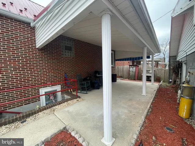 a view of a patio with table and chairs and a barbeque