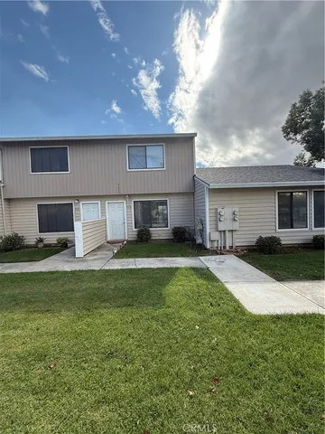 a view of a house with a yard and a patio
