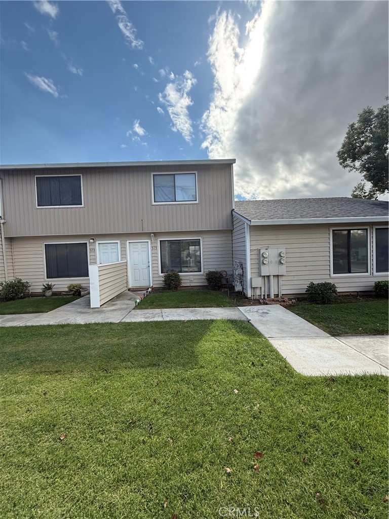 a view of a house with a yard and a patio