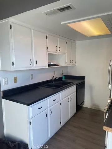 a kitchen with granite countertop white cabinets and sink