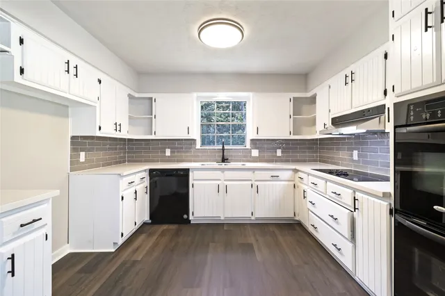 a kitchen with granite countertop white cabinets and white appliances