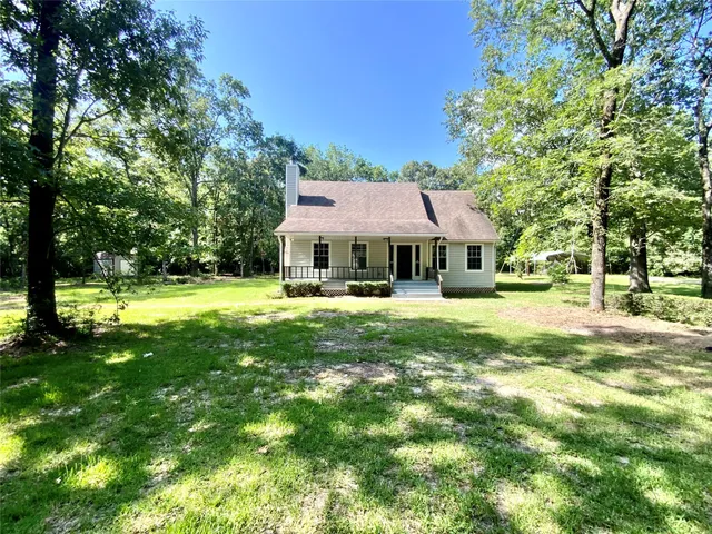 a front view of a house with yard and green space