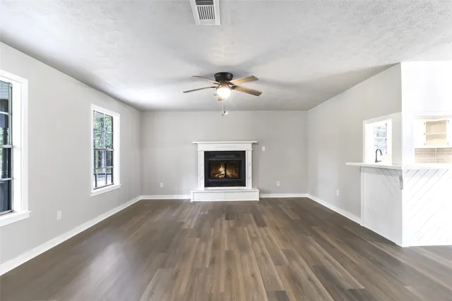 an empty room with windows and a fireplace