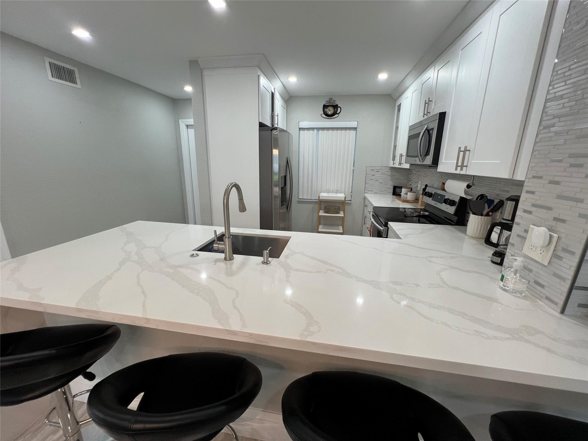 9780 Marina Boulevard, Unit 415 Boca Raton, FL 33428 - Photo 27 of 39 a bathroom with a sink a toilet and a mirror