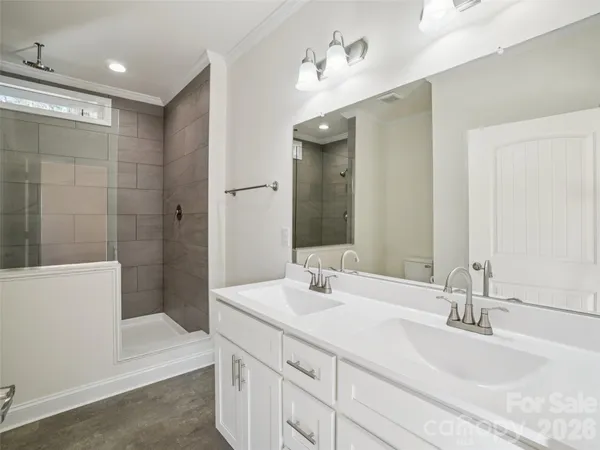 a bathroom with a double vanity sink mirror and shower