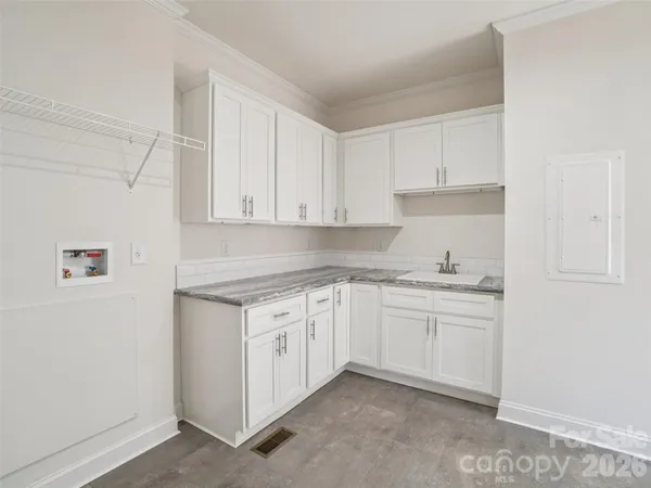 a kitchen with granite countertop white cabinets and white appliances