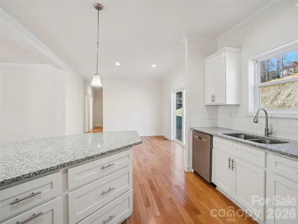a kitchen with granite countertop kitchen island white cabinets and white appliances