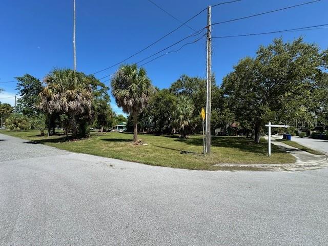 a view of a house with a big yard and palm trees