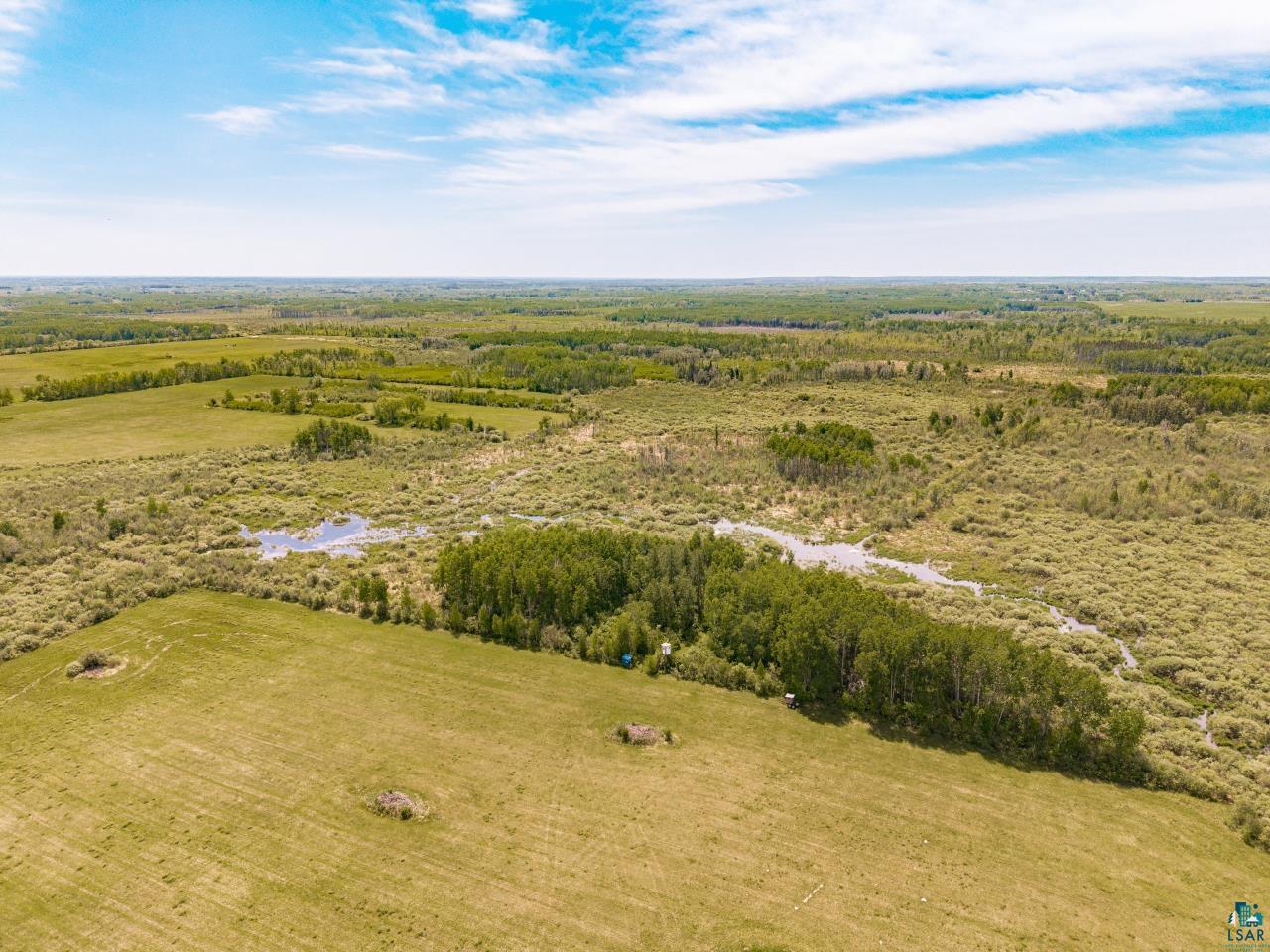 6606 Metso Road Kettle River, MN 55757 - Photo 26 of 84 Expansive natural landscape featuring a mix of open fields, wooded areas, and a visible water body