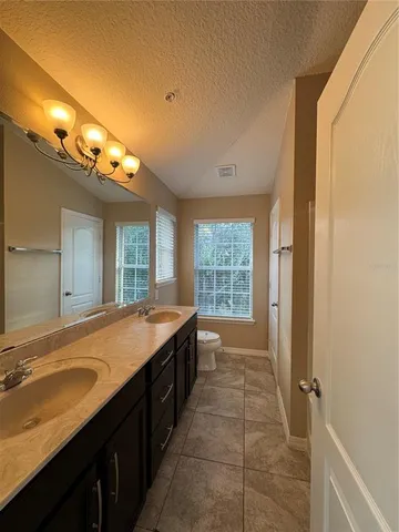 a spacious bathroom with a granite countertop sink and a bathtub