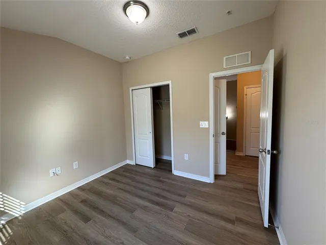 an empty room with wooden floor and mirror