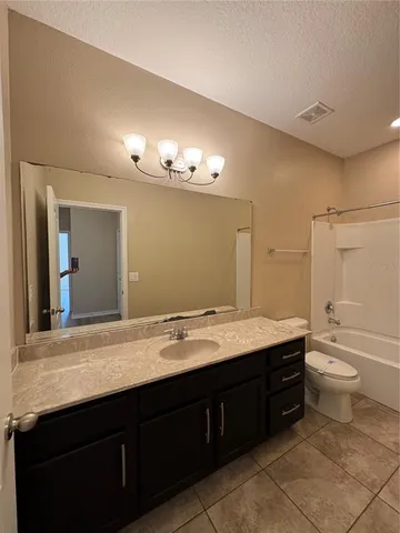 a bathroom with a granite countertop sink toilet a large mirror and a shower