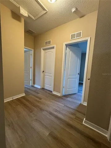 a view of a hallway with wooden floor