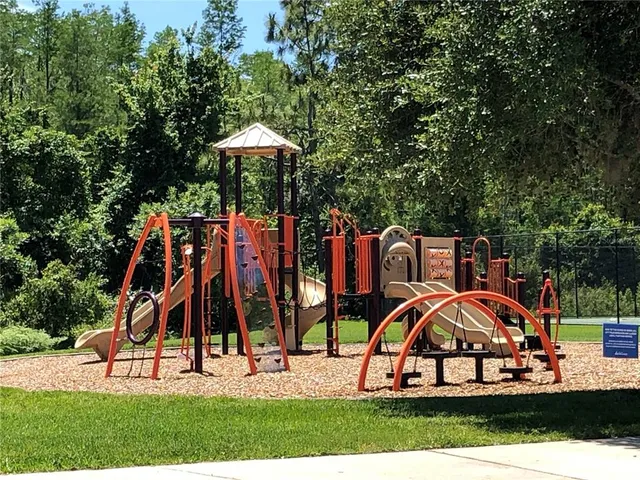 a sign board with a tree and yard