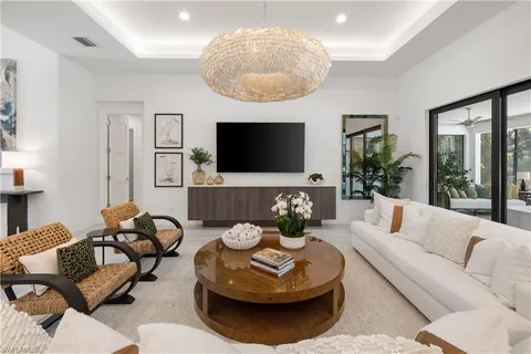 a living room with furniture a large window and a flat screen tv