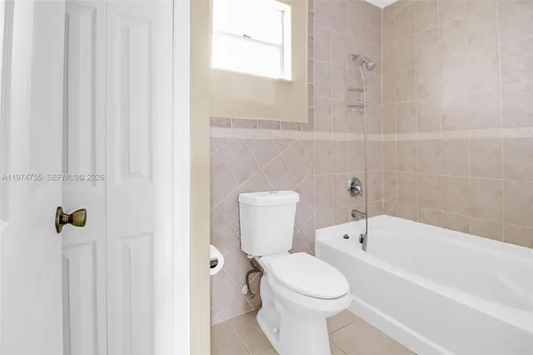 an empty room with white walls and tiles