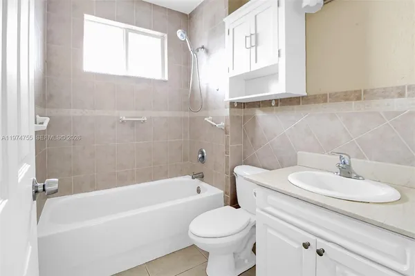 a bathroom with a sink toilet a mirror and bathtub