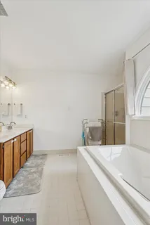 a spacious bathroom with a bathtub sink and mirror