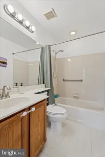 a bathroom with a sink a toilet a mirror and shower