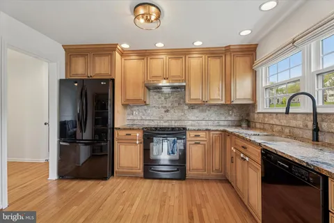 a kitchen with stainless steel appliances granite countertop a refrigerator and a stove top oven