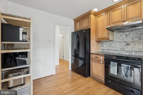 a kitchen with granite countertop a refrigerator stove and oven