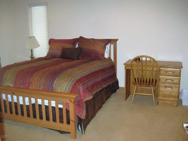 a bedroom with a bed a dresser and chair