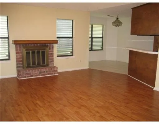 an empty room with windows and fireplace