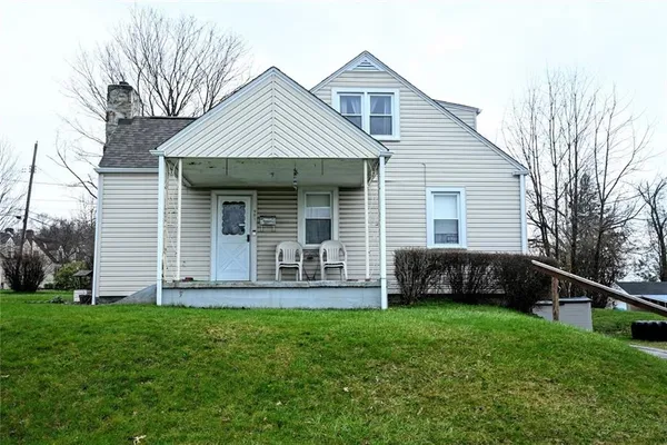 a front view of a house with a yard and green space