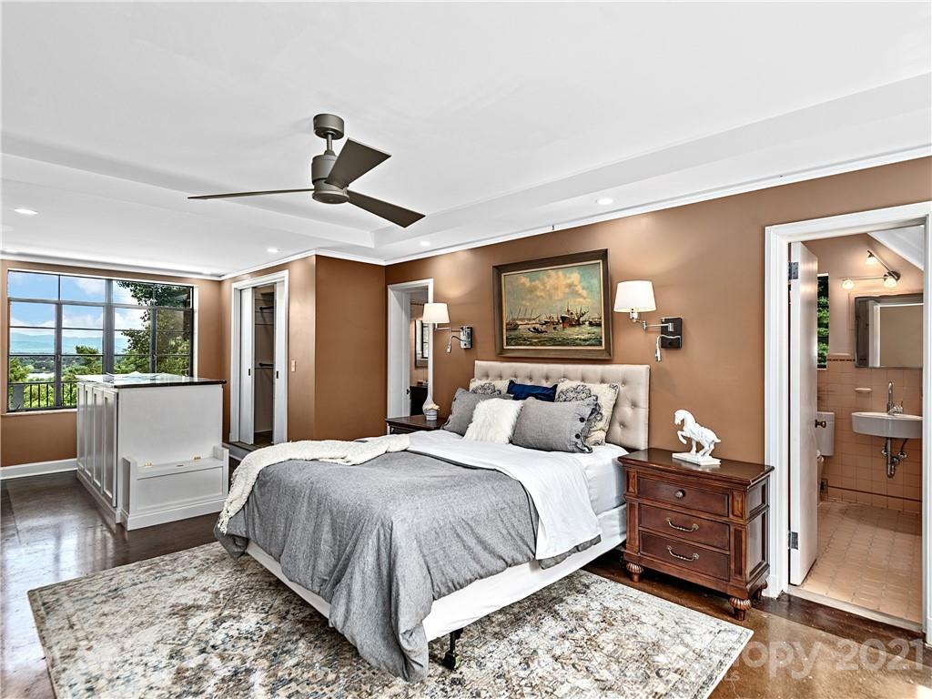 930 Country Club Road Asheville, NC 28804 - Photo 21 of 47 a bedroom with a bed a large window and walk in closet