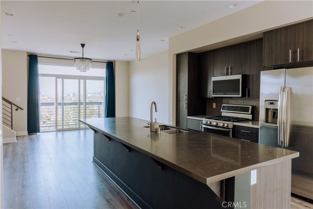 a kitchen with stainless steel appliances a sink a stove and microwave