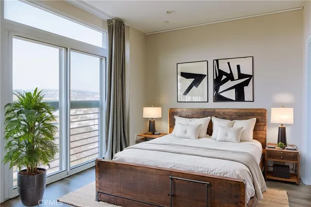 a bedroom with a large bed and a potted plant