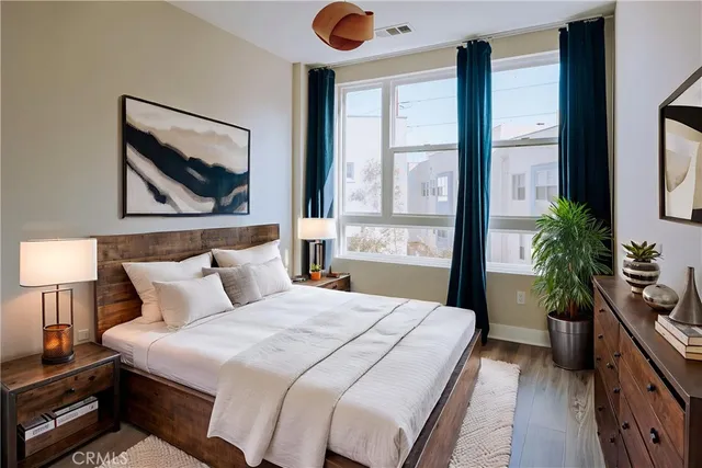 a bedroom with a large bed and a potted plant