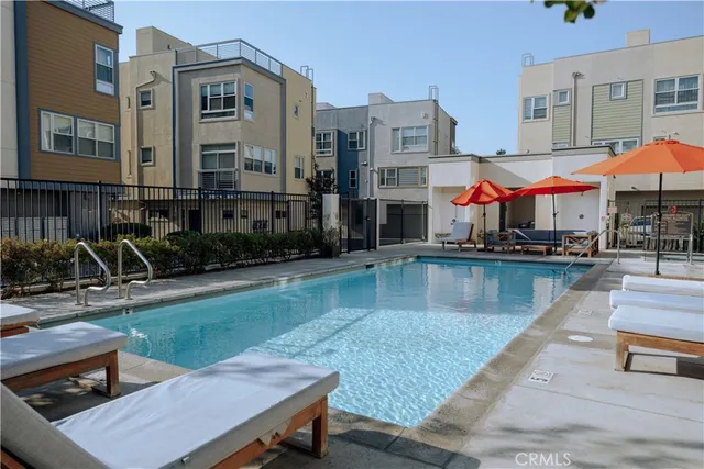 a view of a swimming pool with sitting area and furniture