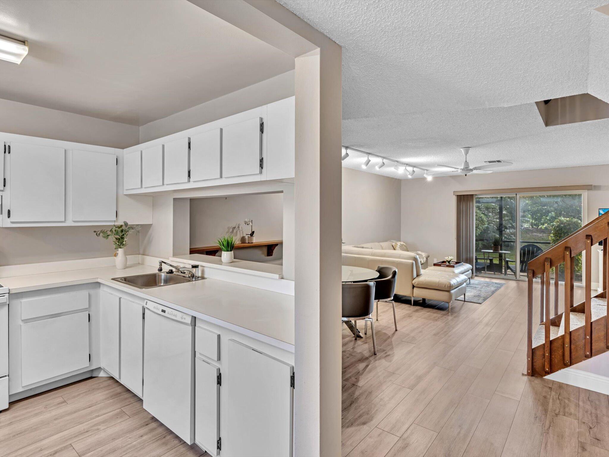 6318 Walk Circle Boca Raton, FL 33433 - Photo 4 of 43 a kitchen with a sink dishwasher stove and white cabinets with wooden floor