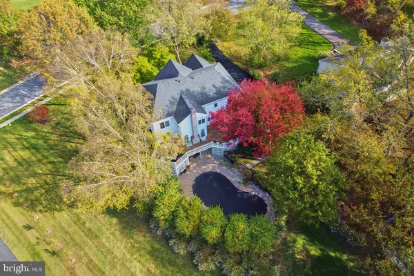 a view of a house with a big yard and large trees