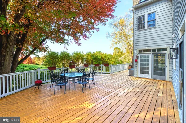 a view of a roof deck with table and chairs and wooden floor