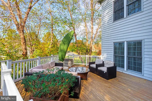 a view of a deck with couches table and chairs with wooden floor and fence