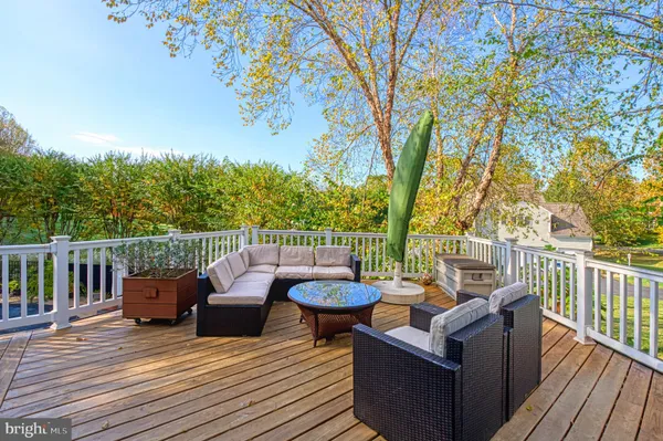 a balcony with wooden floor and outdoor seating