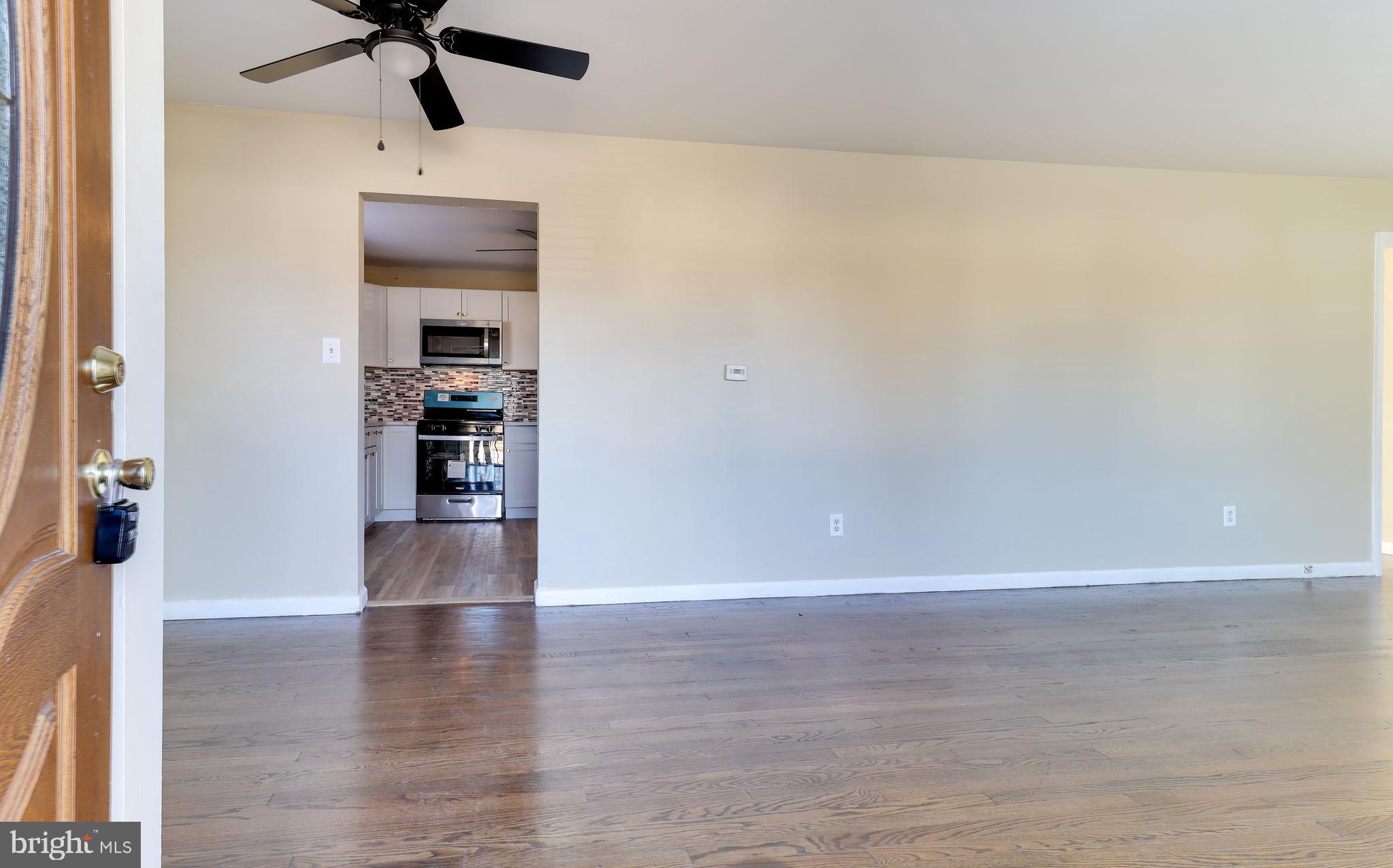 121 Nottingham Road Pennsville, NJ 08070 - Photo 2 of 14 a view of empty room with wooden floor and fan